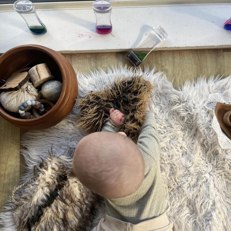 Nursery baby exploring sensory experience at Busy Bees Ashburton 