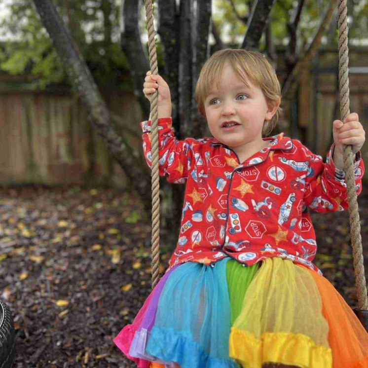 Busy Bees Motueka toddler playing on outdoor swing