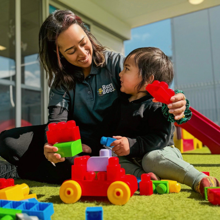 Busy Bees Ormiston child and teacher stacking blocks