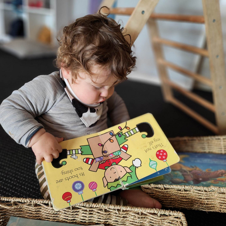 Baby boy immersed in reading at Busy Bees Richmond