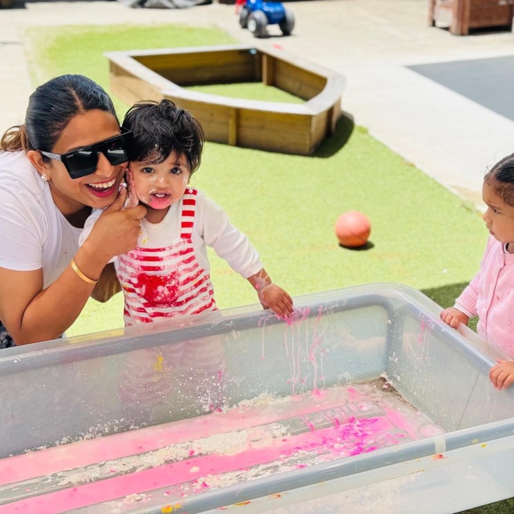 kids with mum enjoying messy play outside at Busy Bees Te Rapa