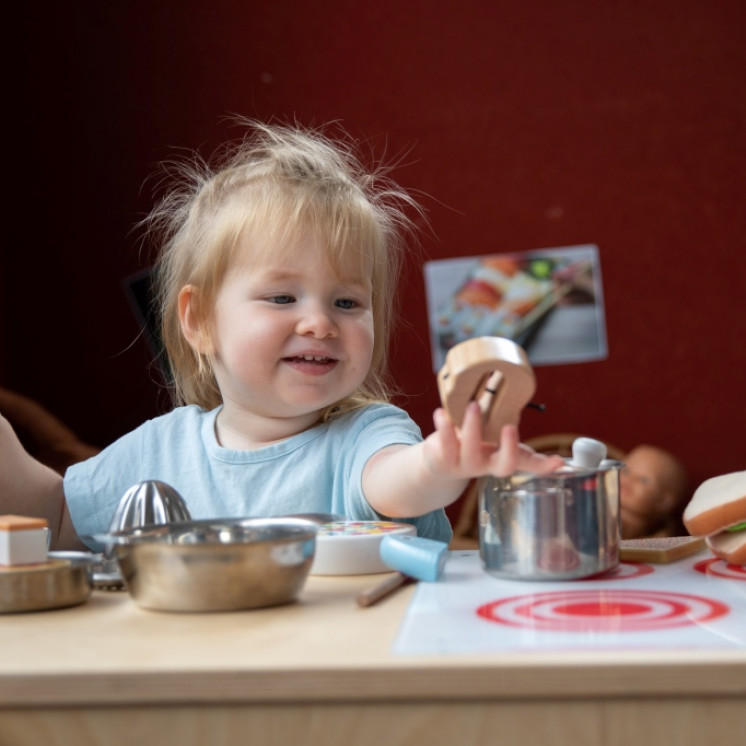 Girl enjoying the play kitchen at Busy Bees Wellington Street