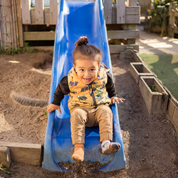 Little boy sliding down the slide at Busy Bees Western Heights