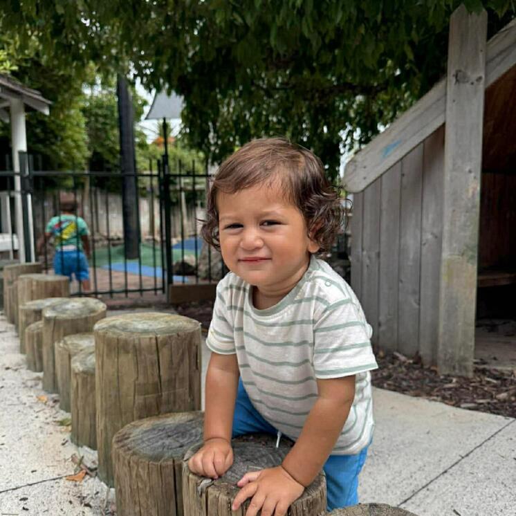 Toddler boy playing outdoors at Busy Bees Whau Valley 
