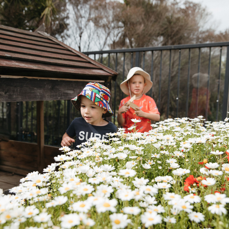 Playing outside with flowers at Grey Lynn Monessori by Busy Bees